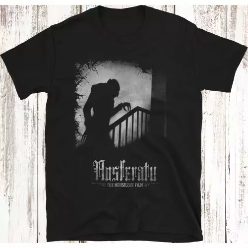 Omarm de elegantie van schaduwen: Draag de iconische silhouet van Nosferatu op je shirt met ons exclusieve T-shirt, gebaseerd op het stille film meesterwerk uit 1922; een icoon van de stille film, schimmige kunst, en comfort ontmoet horror. Bestel nu en d
